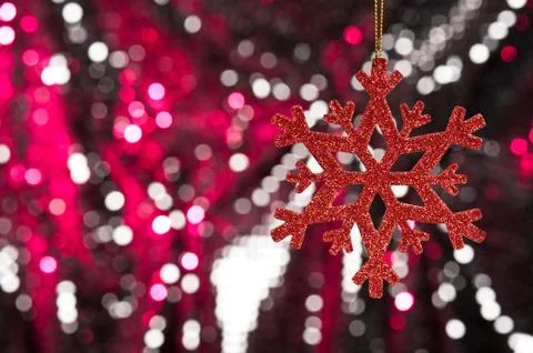 Red snow flake on a red, silver glitter background Stock Photos