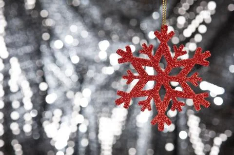 Red snow flake on a silver glitter background Stock Photos