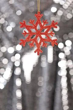 Red snow flake on a silver glitter background Stock Photos