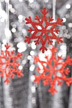 Red snow flake on a silver glitter background Stock Photos