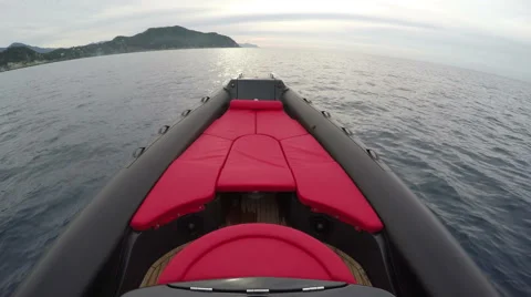 Red sofa on the bow of a rubber boat  Stock Footage 58656861