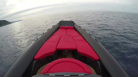 Red sofa on the bow of a rubber boat  Stock Footage 58656887