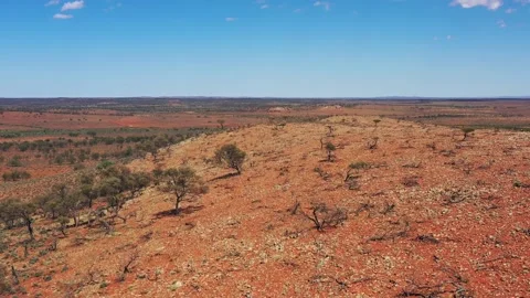 Red soil hill range of bushland outback backward aerial flying travel in 4k. Stock Footage 169920558