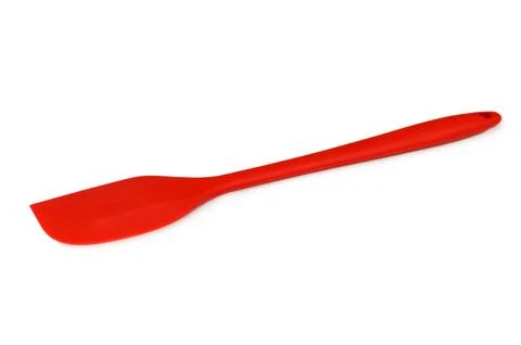 Red spatula resting on white background in side view, neutral mood, kitchen.. Stock Photos