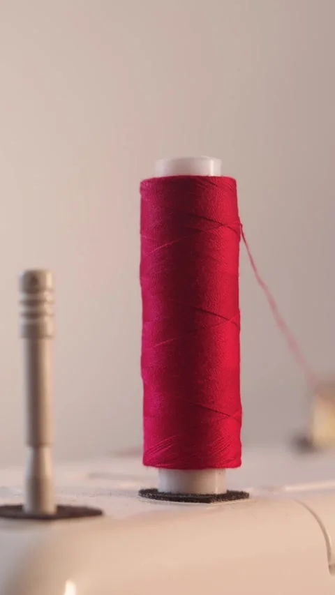 Red spool of thread on a sewing machine Stock Footage 330052457