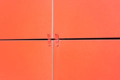 REd square ventilated ceramic panels installed on the facade of the building. Stock Photos