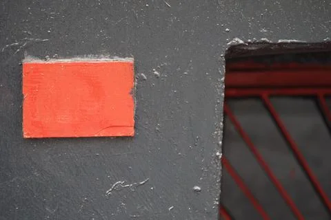 Red square on wall near window with red bars 写真素材