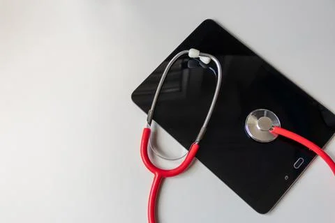 Red stethoscope on black tablet device shows cloud data security digital doctors 写真素材