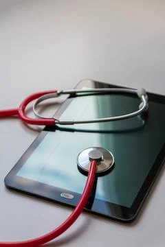 Red stethoscope on black tablet device shows cloud data security digital doctors Stock Photos