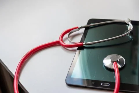 Red stethoscope on black tablet device shows cloud data security digital doctors Stock Photos