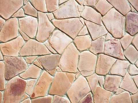 Red stone cladding patterned wall. Wall cladding with terracotta sandstone Stock Photos