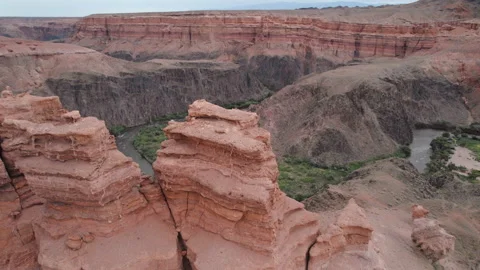 Red stone pillars weathered in canyon aerial view. River flowing among mountains Stock Footage 219946168