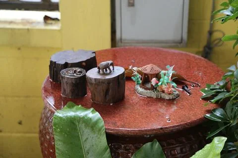 On the red stone table, there is an elephant-shaped wooden ring box and thr.. Stock Photos