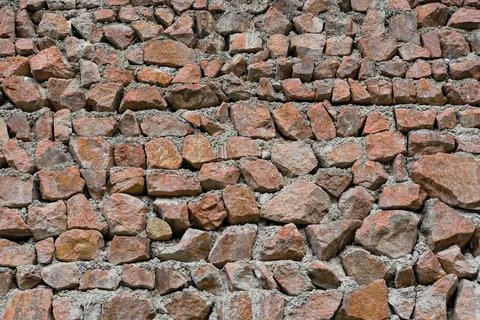 Red stone wall texture background with natural rough rocks and mortar Stock Photos
