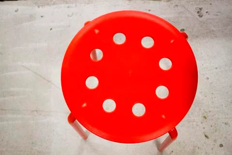 Red stool on the cement floor, texture, background Foto stock