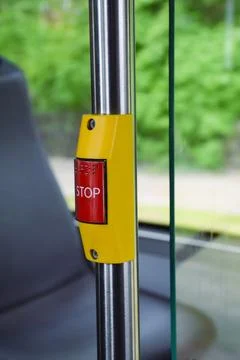Red STOP button with braille on a yellow mount attached Stock Photos