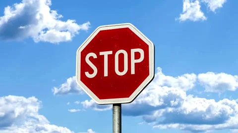 Red stop sign and white letter on the street isolated on the blue sky and clouds Stock Footage 313061933