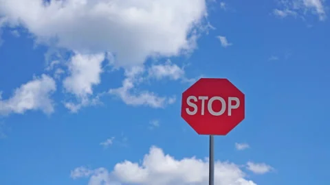 Red stop sign on a background of blue sky with clouds Stock-Footage 115952608