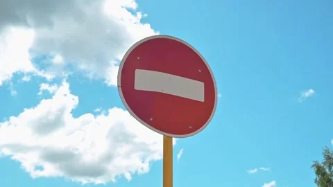 A red stop sign stands tall against a bright blue sky filled with clouds, Stock Footage 339004636