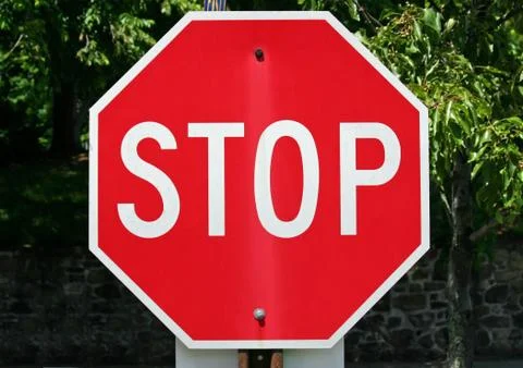 A red stop sign with trees in the background 스톡 사진