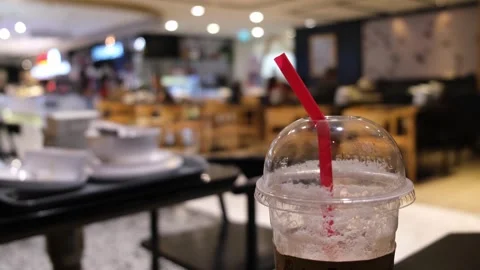 Red straw in a plastic disposable cup and dishes on the table at a Stock Footage 257600655