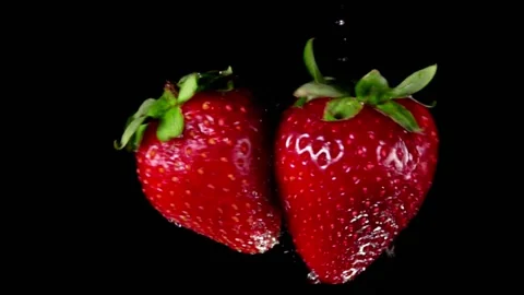 Red strawberries are flying to each other and colliding on the black background Stock Footage 137904604