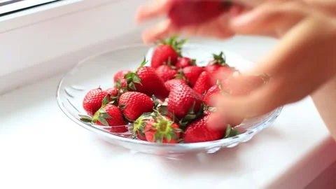Red strawberries quickly disappear from the plate. Hands pick strawberries Stock Footage 130319873