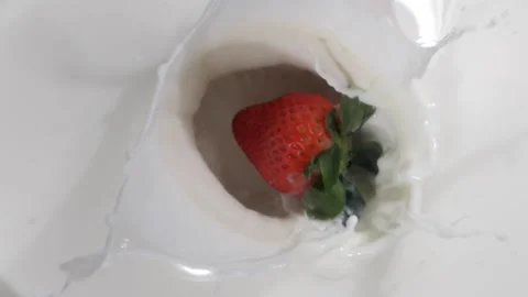 Red strawberry falling and splashing into milk or yoghurt slow motion Stock Footage 150427427