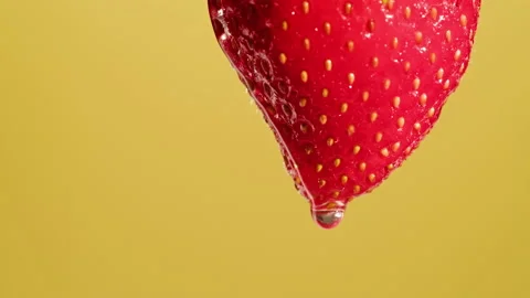 Red strawberry isolated on yellow background, juicy ripe berry close-up, sweet Stock Footage 195531258