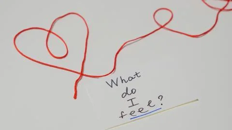 Red string forming heart shape with handwritten note on white background Stock Photos