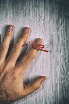 Red String Tied Around a Finger. Memory and Reminder Knot Stock Photos