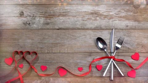 Red strips fork, spoon, knife on wooden table Stock Photos