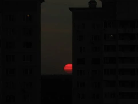 Red sun behind the building Stock Photos
