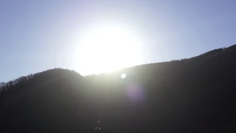 Red sun disk wakes up dawn with current cloudy waves above beautiful hills Stock Footage 97811596