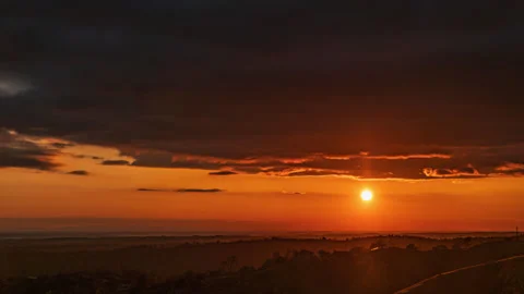 Red Sun Drops Below Clouds in Dramatic Sunset Timelapse Stock Footage 278296277
