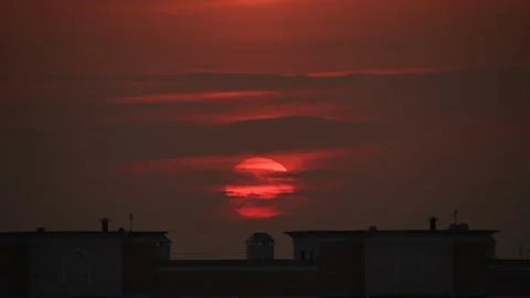 Red sun goes down behind the building silhouette Stock Footage