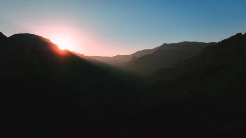 Red sun rising through the mountains Stock Footage 240483938