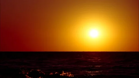 The red sun sets over the horizon into the ocean. A celestial body sinks into Stock Footage 116674130