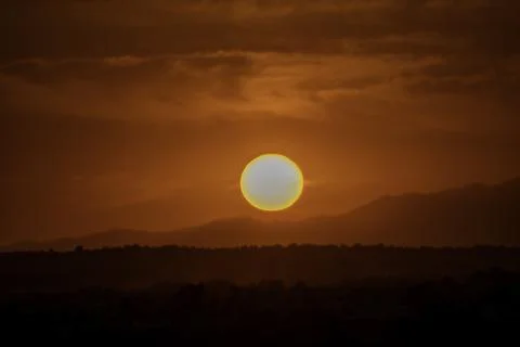 Red sun setting over the mountains Stock Photos