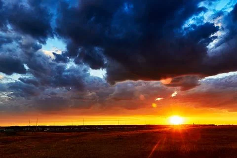 Red sunset with clouds after rain in the steppe Foto stock