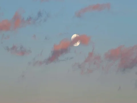 Red sunset clouds passing in front of full moon. Video stock 85305160