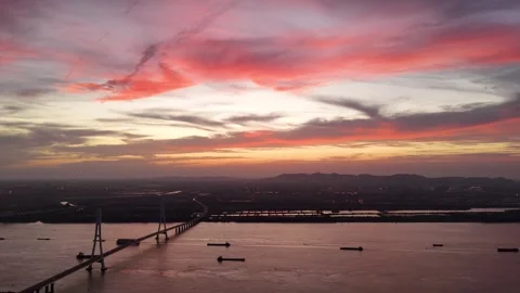 Red sunset drone view of modern bridge over river in China Stock Footage 337756677