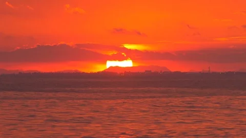 Red Sunset over Ocean behind Town and Mountains Stockbeeldmateriaal 116941259