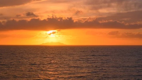 Red sunset over the sea from a ship with a view of a small island 動画素材 106472496