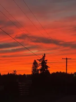 Red sunset with power lines over the countryside Stock Photos