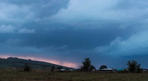 The red sunset shines through between the mountains and dark clouds Stock Photos