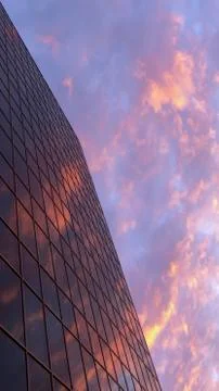 The red sunset of the sky with clouds is reflected in the glass of a typical  Stock Photos