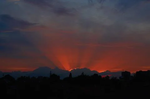 Red sunset through clouds on the blue sky horizontally Stock Photos