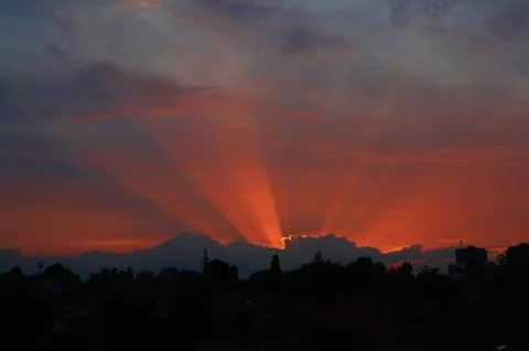 Red sunset through clouds on the blue sky horizontally Stock Photos