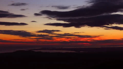 Red sunset from a top of a mountain with a view on the sea - timelapse. Stock Footage 45971813